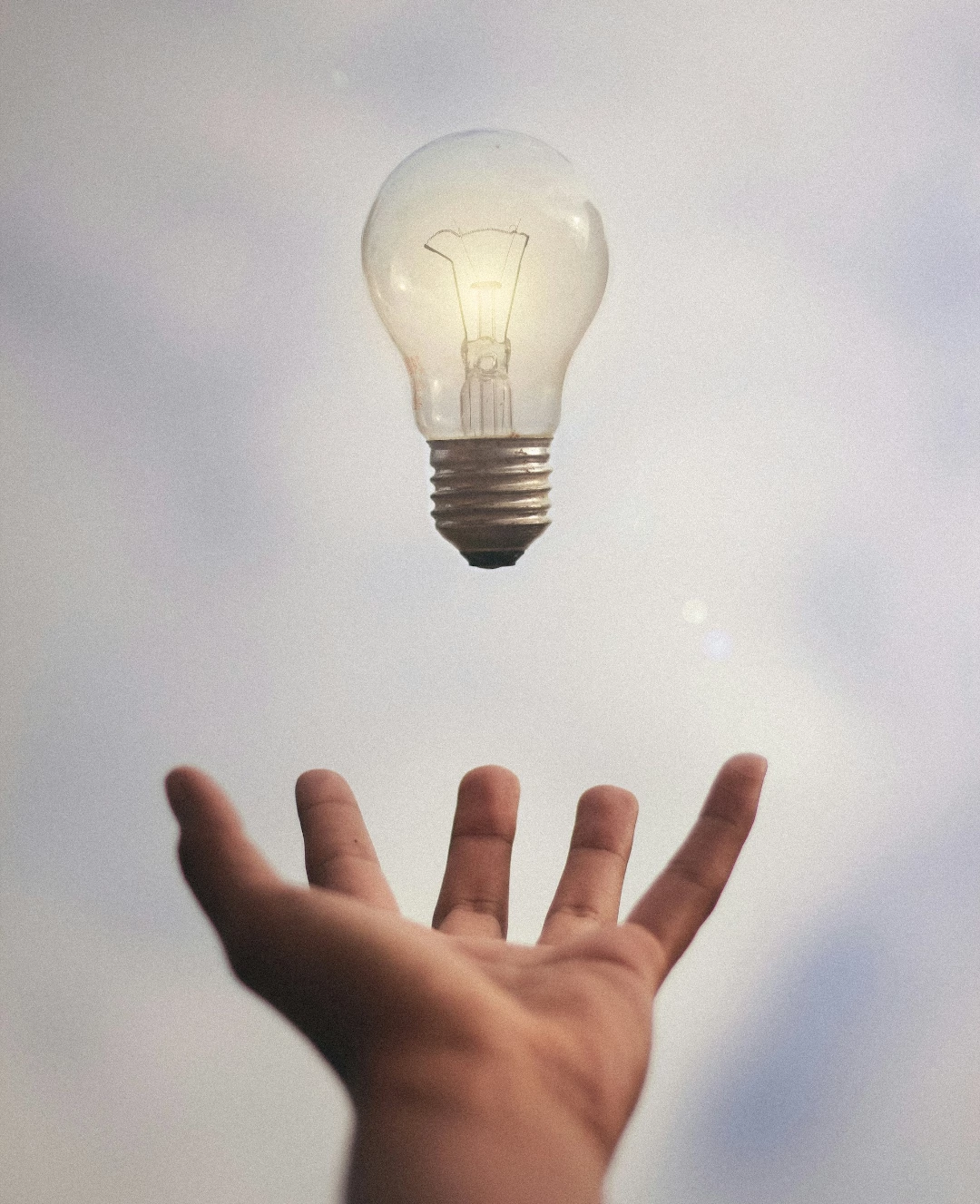 illustration d'une ampoule en lévitation au-dessus d'une main ouverte